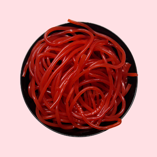 Rode aardbeienvetersnoep in zwart bakje