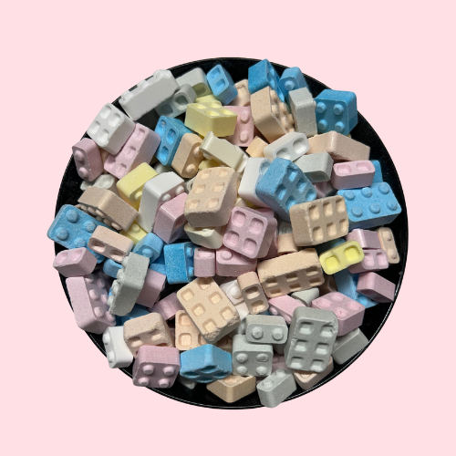 Roze, gele, blauwe, groene en witte Candy Bricks snoepjes in zwart bakje