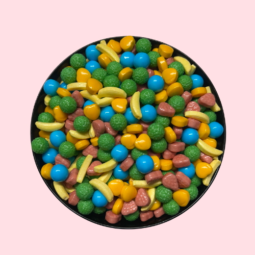 Groene, rode, oranje, gele en blauwe Candy Nippers snoepjes in zwart bakje