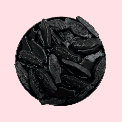 Zwarte dubbelzoute dropvissen snoep in zwart bakje