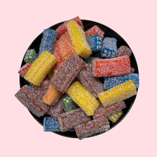 Gesuikerde zure Fizzy Bricks blauw, geel, oranje en rood in zwart bakje