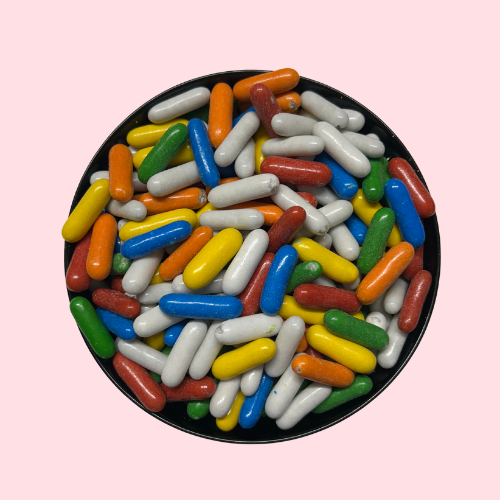 Oranje, rode, witte, gele, blauwe en groene Kleurendrop snoepjes in zwart bakje