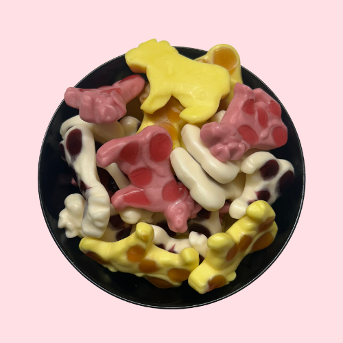 Gele, roze en witte koeien-snoepjes in zwart bakje