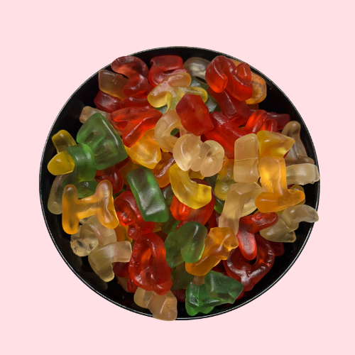 Witte, oranje, gele, groene en rode lettersnoepjes in zwart bakje