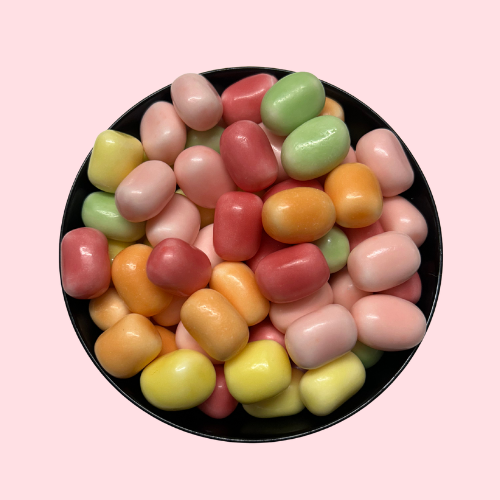 Oranje, roze, groene en gele Maoam Fruit snoepjes in zwart bakje