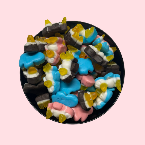 Witte pinguïnsnoepjes met roze, blauw, zwart en geel in zwart bakje