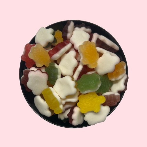 Gele, groene en rode schildpadden-snoepjes met witte onderkant in zwart bakje