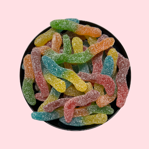 Gesuikerde zure wormen in blauw, geel, rood, groen en oranje in zwart bakje