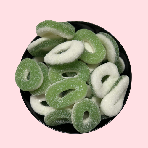 Gesuikerde wit-groene appelringen in zwart bakje