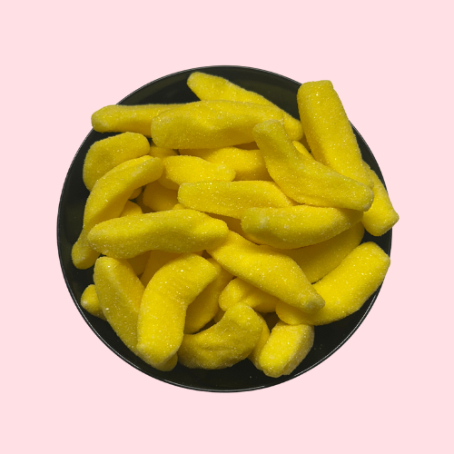 Gesuikerde gele banaantjes in zwart bakje