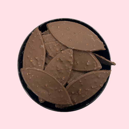 Melk chocolade in vorm van blaadjes in zwart bakje