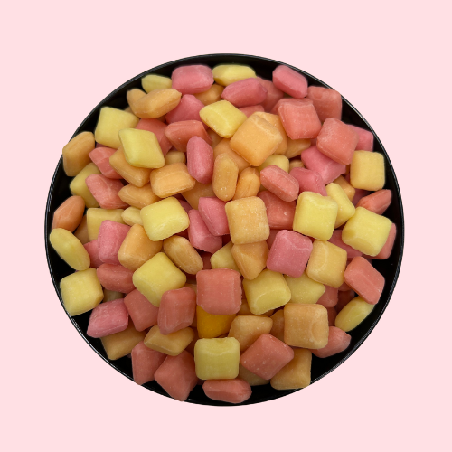 Roze-geel-oranje chewy candy in zwart bakje