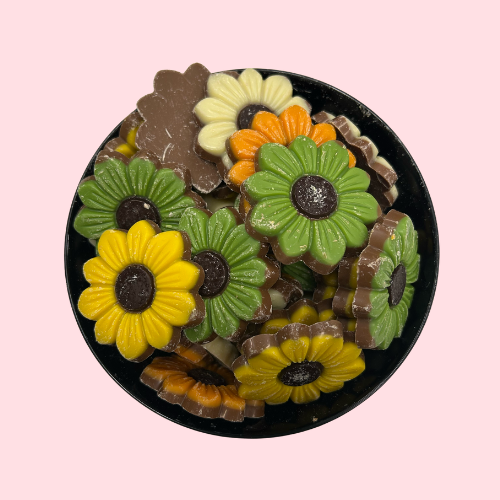 Melk chocolade in vorm van bloemen geel groen oranje in zwart bakje