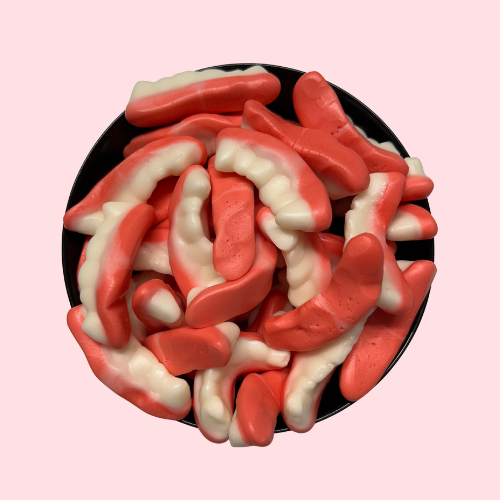 Roze-witte Dracula Tanden snoepjes in zwart bakje