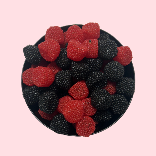 Rode en zwarte frambozen- en bramensnoepjes in zwart bakje