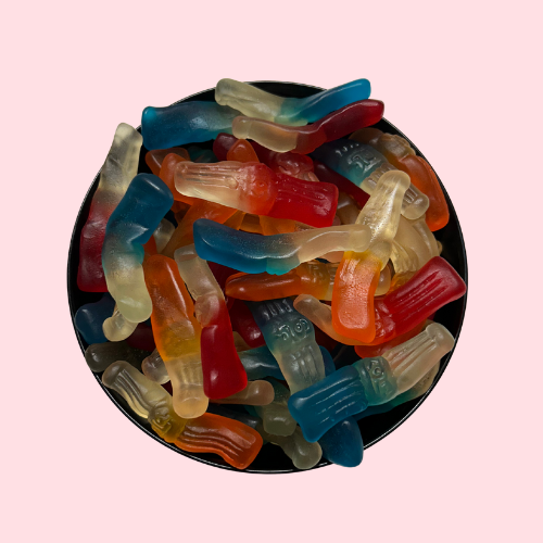 Witte, oranje, rode en blauwe fruitflesjes snoepjes in zwart bakje