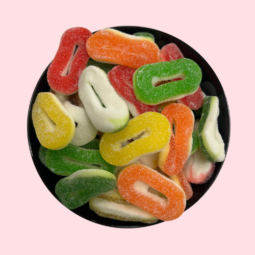 Fruit ringen snoep, geel rood oranje groen, in zwart bakje