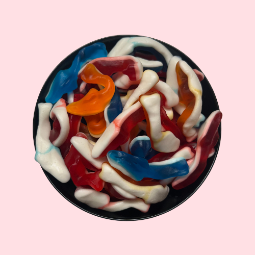 Oranje, rode en blauwe haaiensnoepjes in zwart bakje