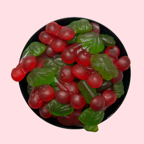 Rode kersjes met groene steeltjes in zwart bakje