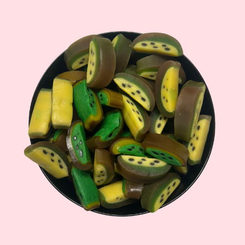 Groen-gele kiwi slices snoepjes in zwart bakje