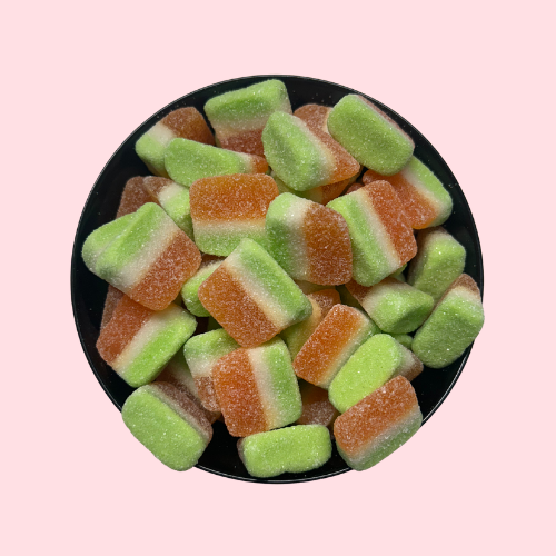 Gesuikerde mango schijfjes oranje en groen in zwart bakje