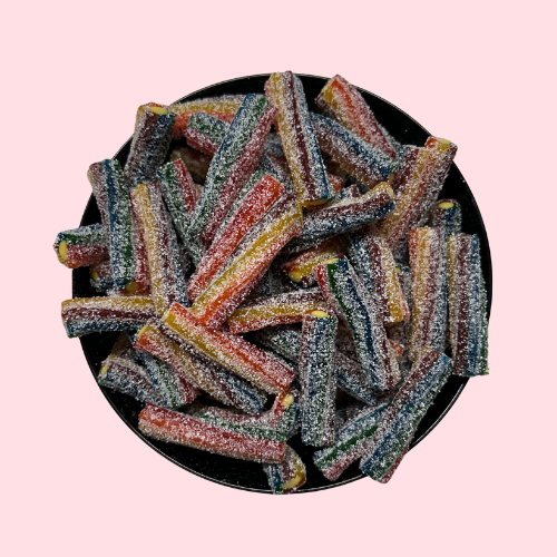 Gesuikerde zure Mega Sour Rainbow Bites met regenboogkleuren in zwart bakje