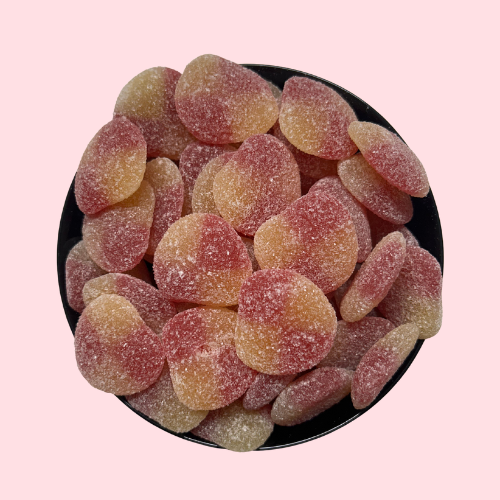 Perziken snoep oranje geel in zwart bakje