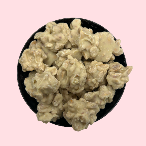 Witte chocolade roosjes met pinda in zwart bakje 