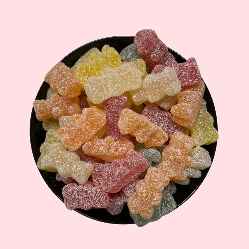 Gesuikerde zure beertjes rood-oranje-geel in zwart bakje